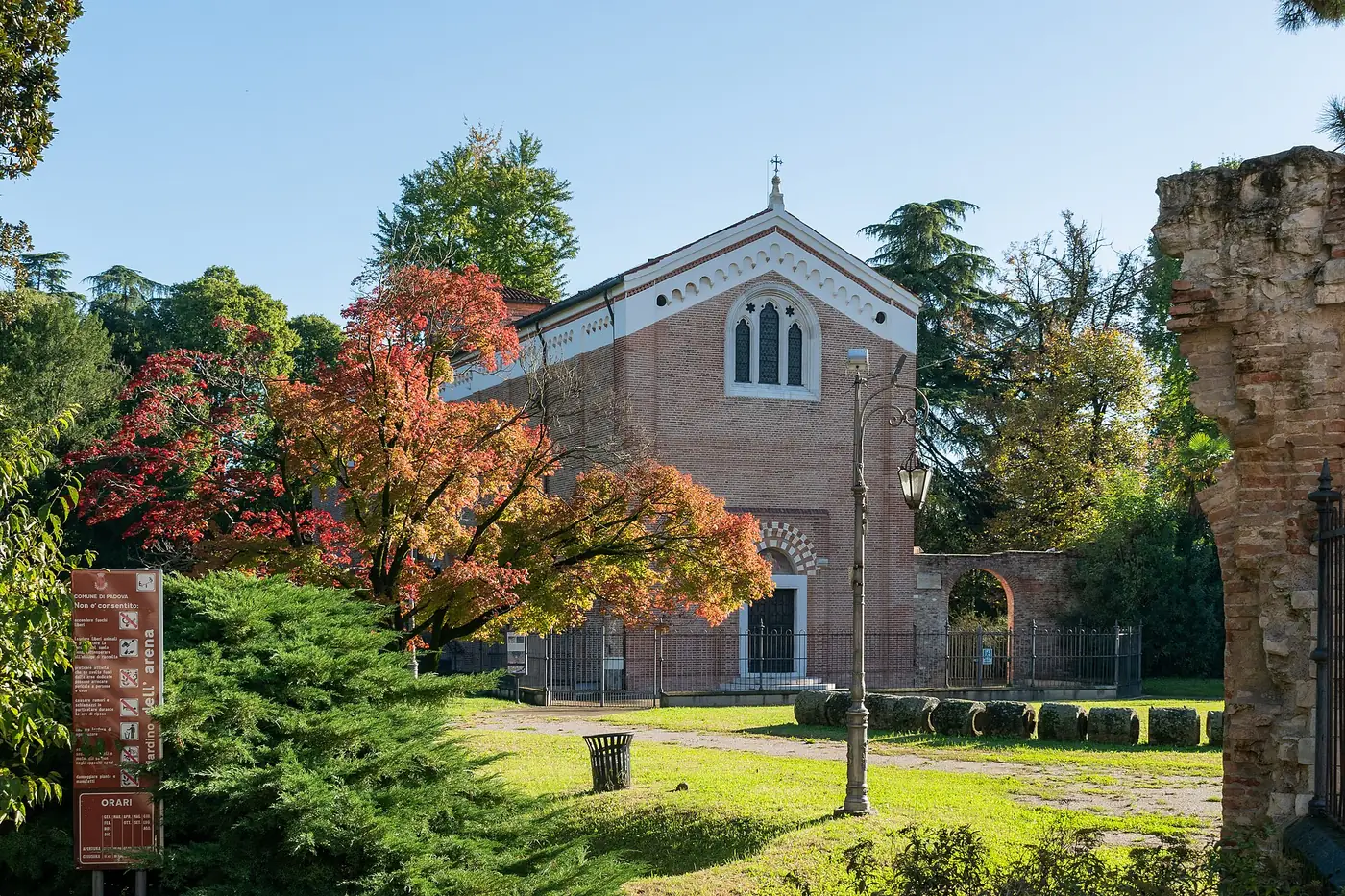 The plain brick front of the Scrovegni Chapel among trees in Padua's Arena gardens